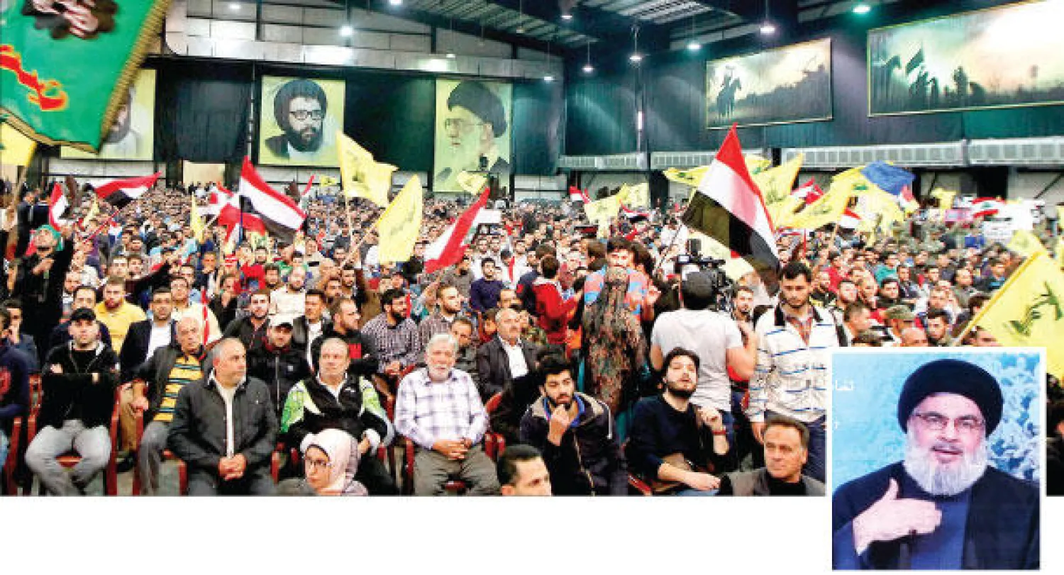 أنصار لحزب الله لدى استماعهم لكلمة أمينه العام حسن نصر الله أول من أمس (إ.ب.أ) الذي يبدو في الإطار أسفل الصورة (أ.ف.ب)