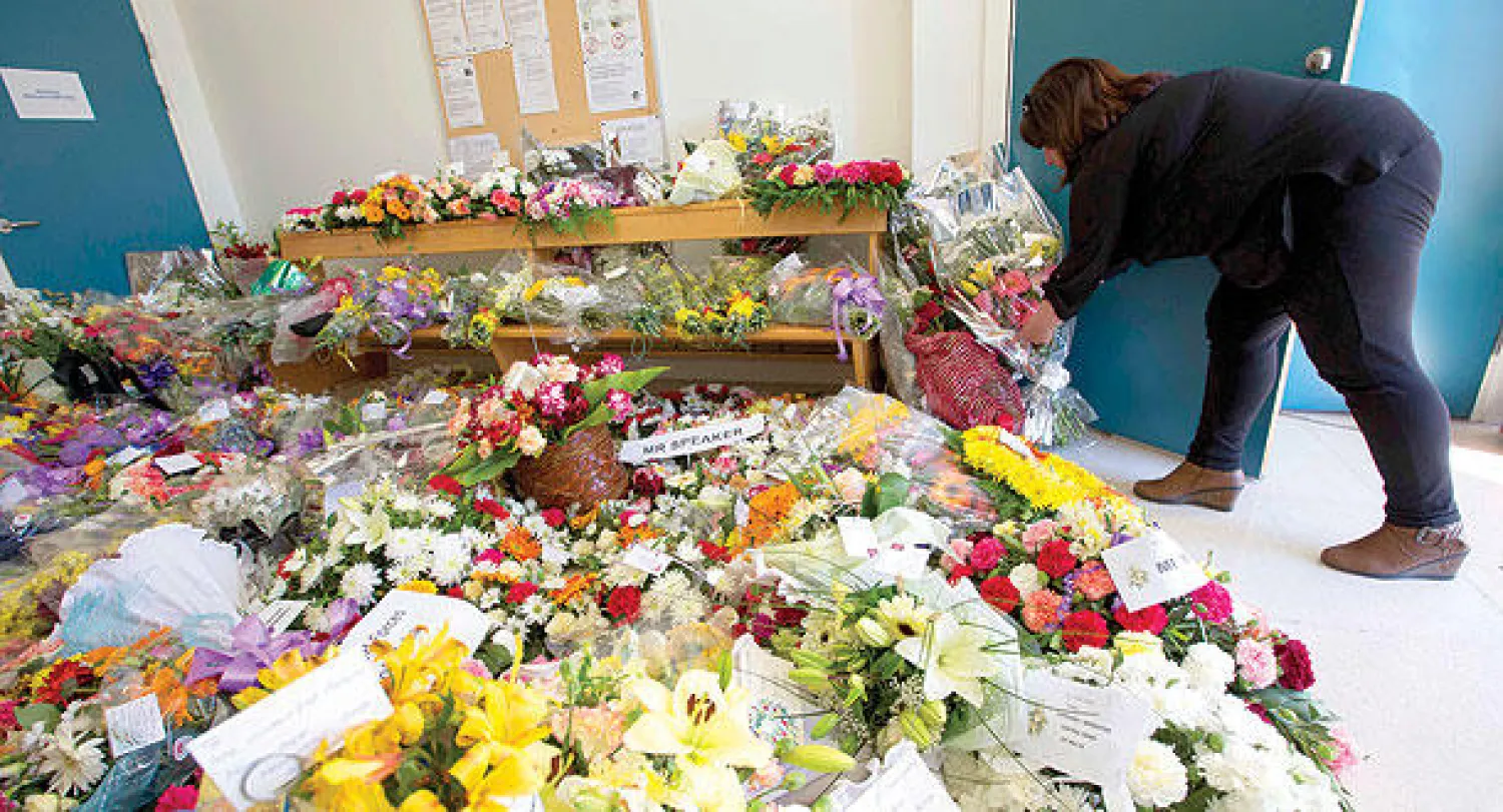 معلمة من مالطا تضع باقة ورود أمام مستشفى في العاصمة فاليتا حيث ترقد جثث 24 مهاجرا غير شرعي غالبيتهم من السوريين كانوا على متن القوارب التي غرقت في المتوسط (أ.ب)