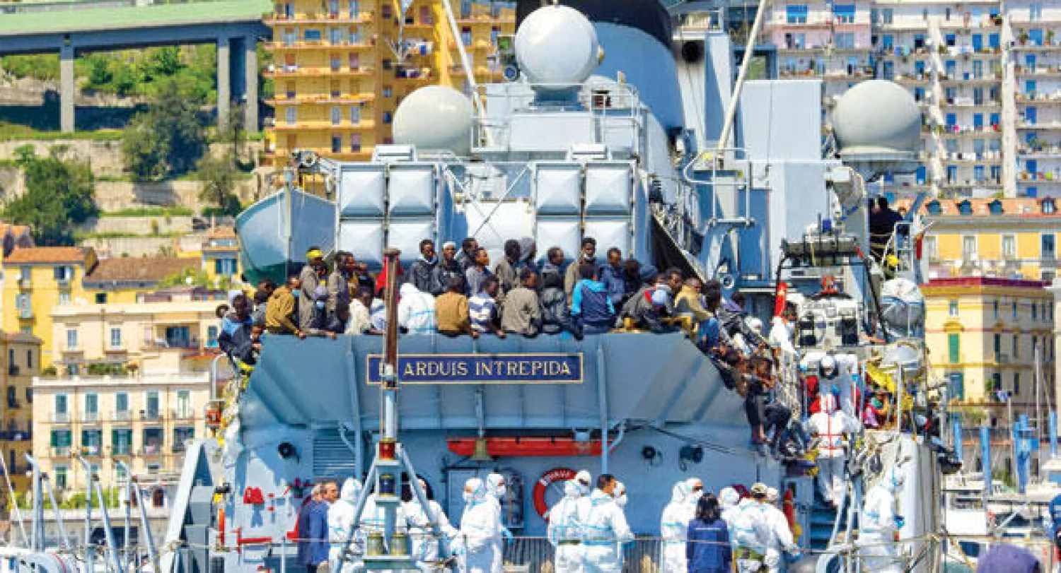 مجموعة من 545 مهاجرا يصلون على متن سفينة تابعة للبحرية الإيطالية إلى مدينة ساليرنو الإيطالية أمس (إ.ب.أ)