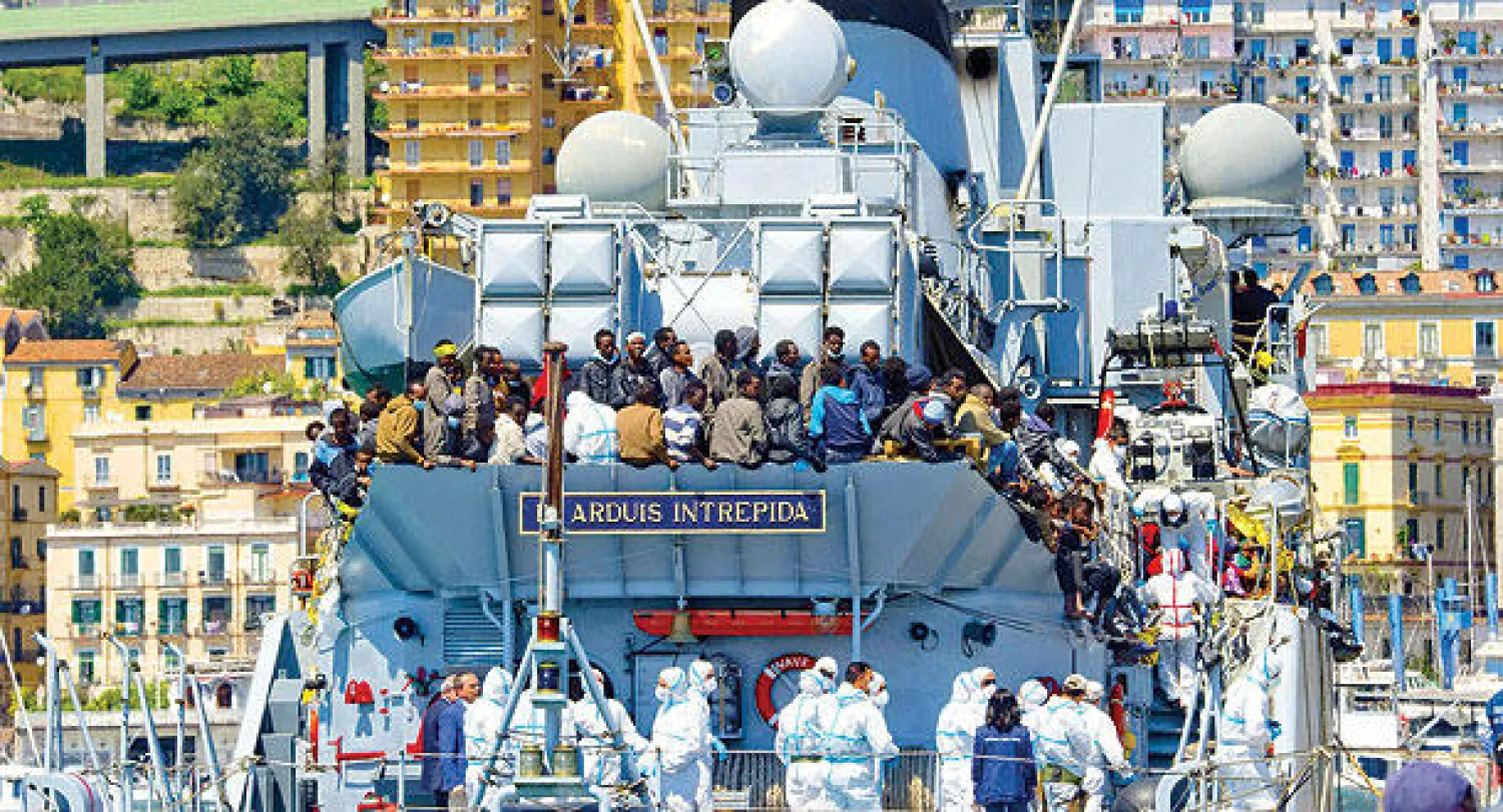 مجموعة من 545 مهاجرا يصلون على متن سفينة تابعة للبحرية الإيطالية إلى مدينة ساليرنو الإيطالية أمس (إ.ب.أ)