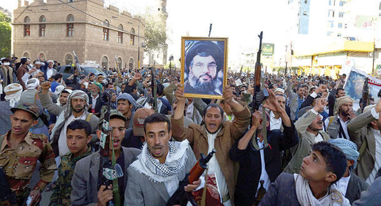 حوثيون يرفعون أسلحتهم وصورة للأمين العام لحزب الله اللبناني حسن نصر الله خلال مظاهرة في صنعاء أمس (إ.ب.أ)