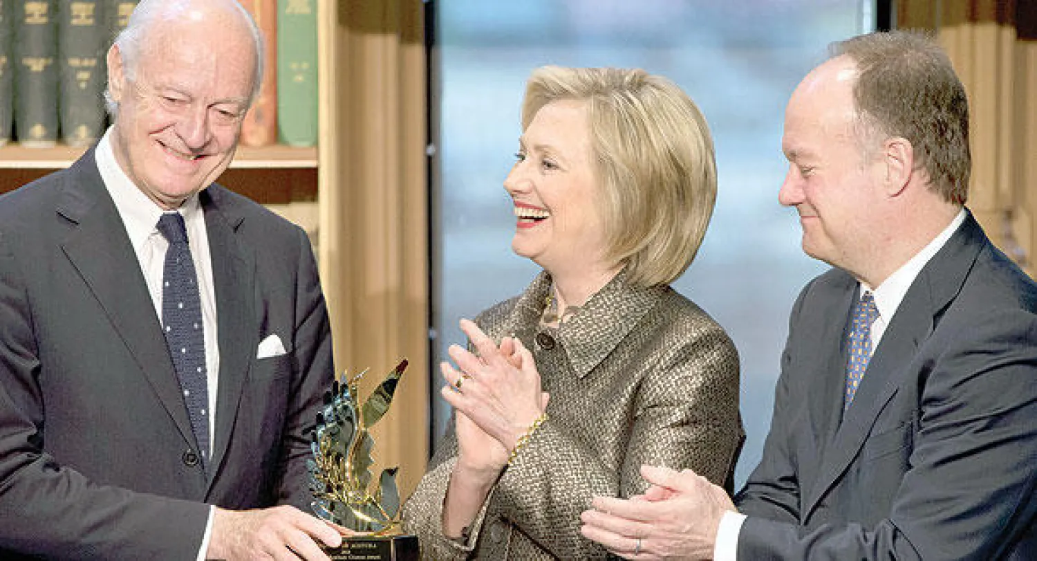 مبعوث الأمم المتحدة السابق إلى أفغانستان ومبعوثها الحالي إلى سوريا ستيفان دي ميستورا يتسلم جائزة هيلاري كلينتون لتقدم المرأة  في عملية السلام كونه ساهم في دعم المرأة الأفغانية ويبدو من اليمين رئيس جامعة جورج تاون حيث أقيم الاحتفال (أ.ب)