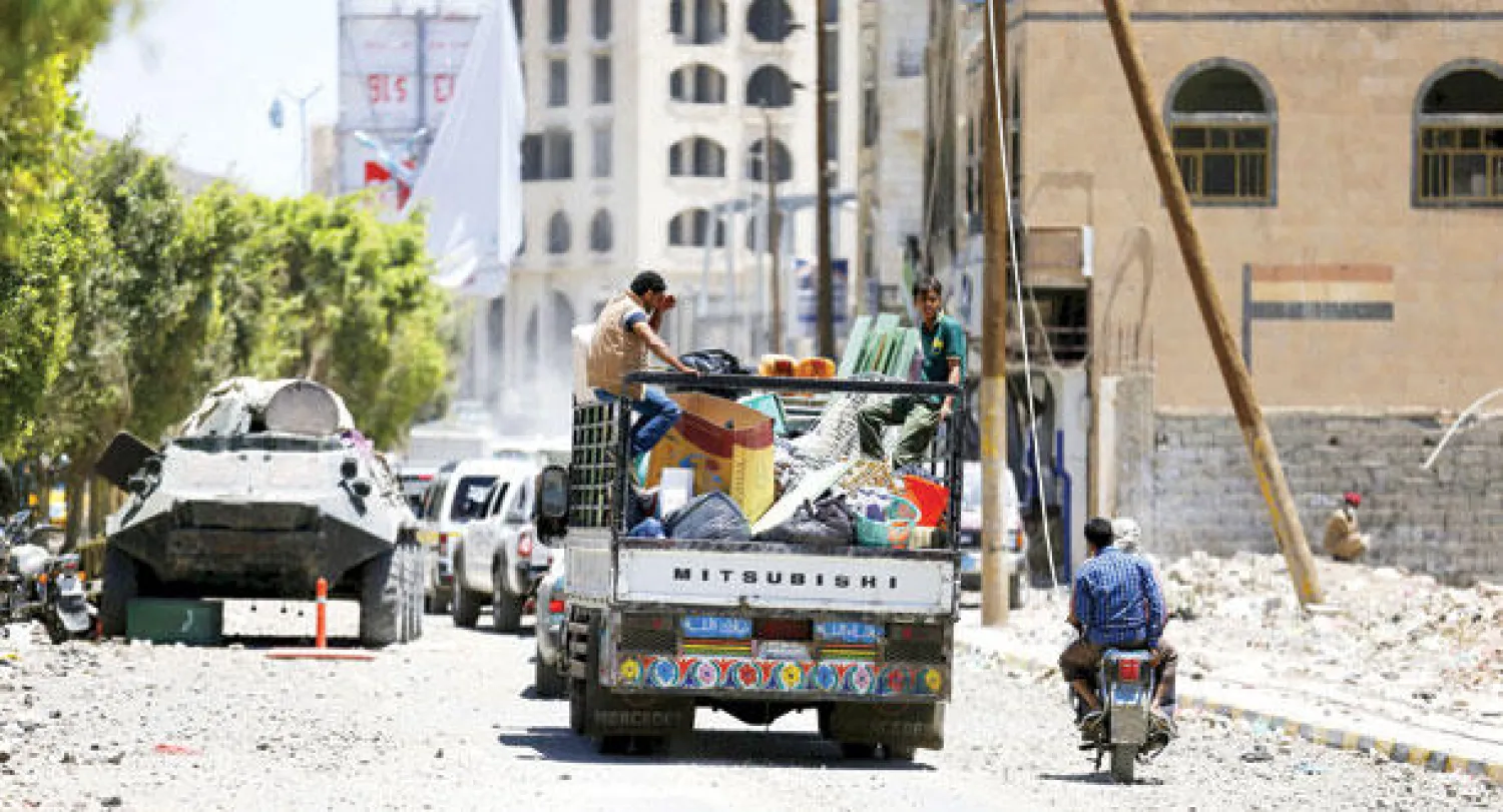 يمنيون في شاحنة نقل إثر تعرض أحد أحياء صنعاء للقصف أمس (رويترز)