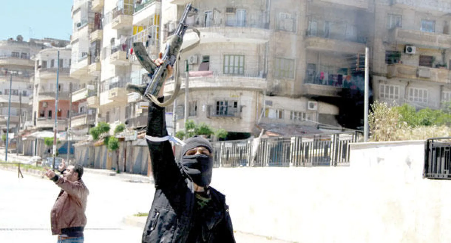 مسلح من جبهة النصرة يحتفي بسيطرة الجبهة التابعة لتنظيم القاعدة على منطقة جسر الشغور أمس (رويترز)