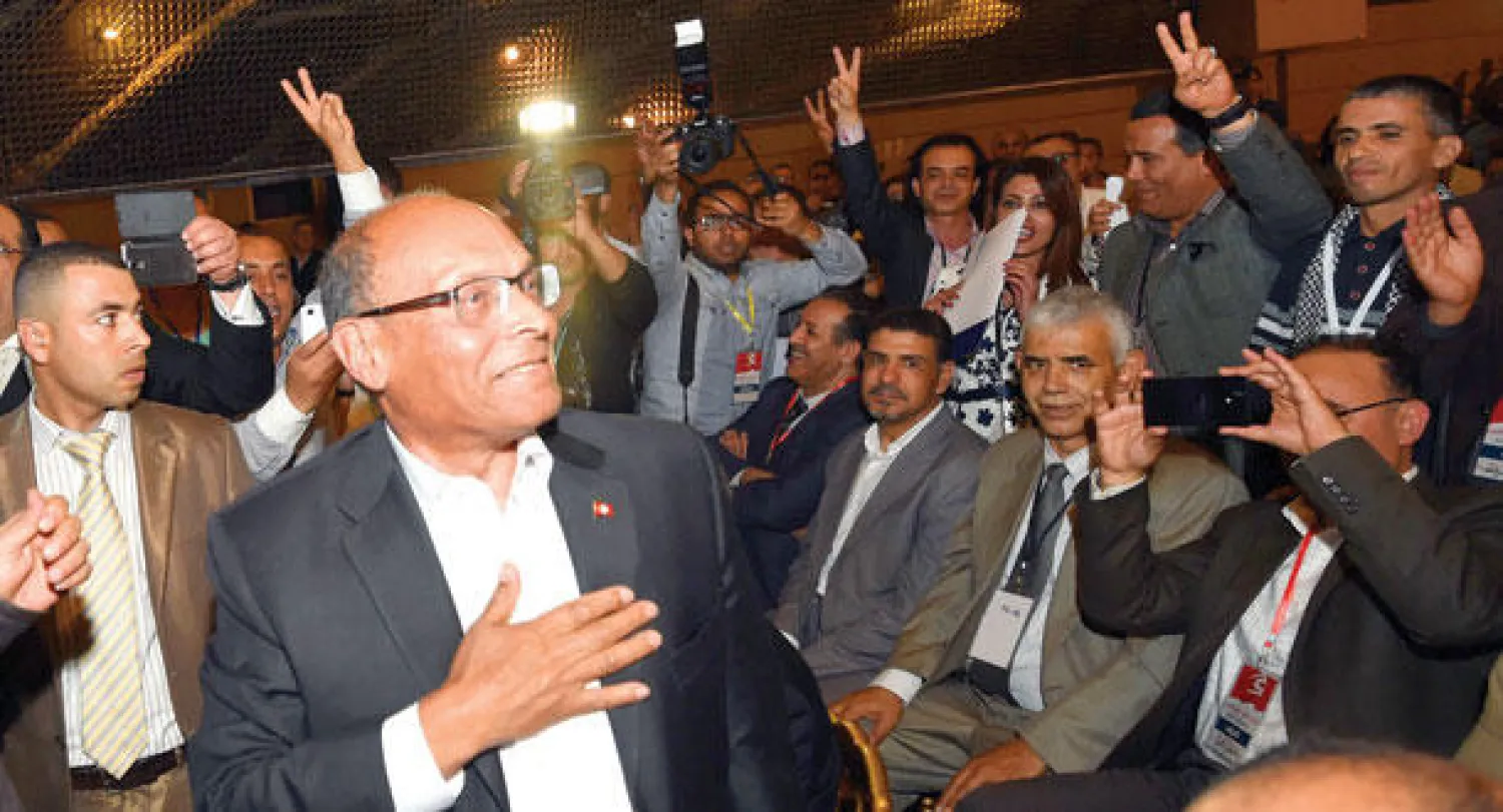 الرئيس التونسي السابق منصف المرزوقي يبتسم لمؤيديه قبيل أول اجتماع لحزبه الجديد {حراك شعب المواطنين} في تونس العاصمة أمس (أ.ف.ب)