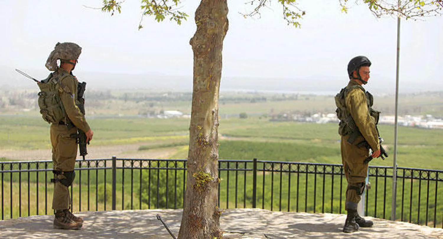 جنديان إسرائيليان قرب مدينة القنيطرة على الحدود السورية بعد سقوط قذيفتين من الحرب الدائرة في الجوار (أ.ف.ب)