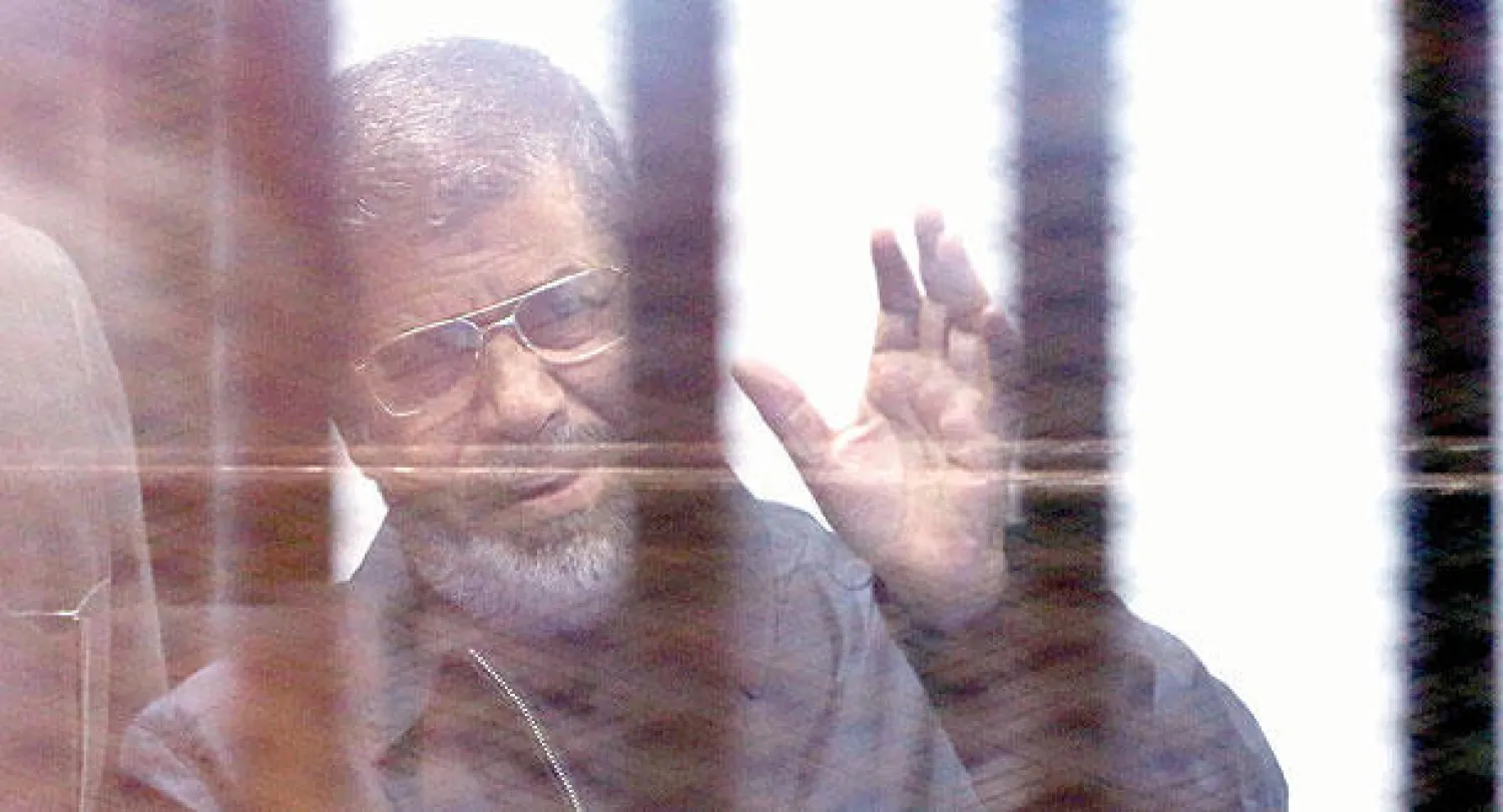 الرئيس المخلوع محمد مرسي بالبدلة الزرقاء خلف القضبان للمرة الأولى (إ.ب.أ)