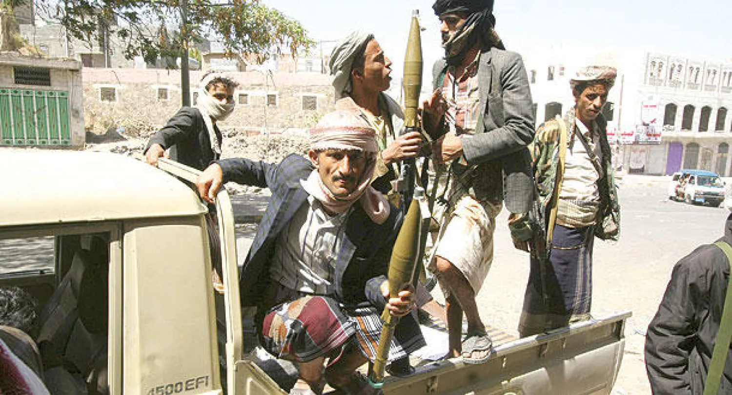 عناصر المقاومة أثناء تنقلهم في عربة نقل لتأمين شوارع تعز أمس (رويترز)