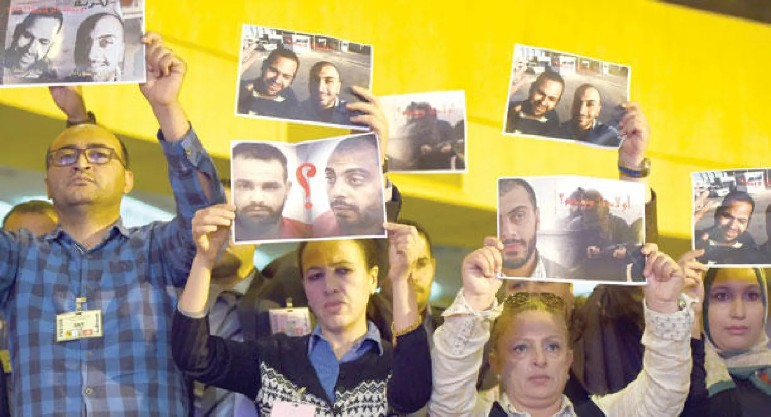 صحافيون تونسيون يرفعون صور زميليهما سفيان الشرابي ونذير القطاري اللذين اختفيا في ليبيا منذ العام الماضي وذلك في الاحتفال بيوم العمال أمس (ا.ف.ب)