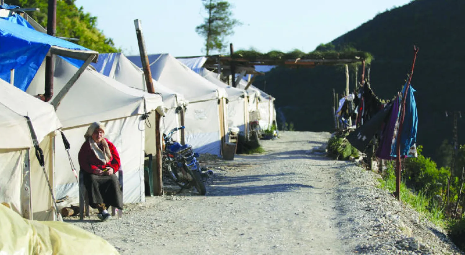 نازحة سورية تجلس خارج خيمتها في مخيم {ريحانية} بجبل التركمان بمحافظة اللاذقية بالقرب من الحدود السورية - التركية (رويترز)