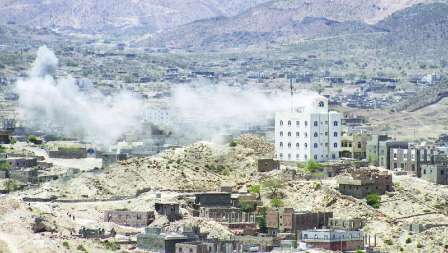 الدخان يتصاعد في أحد الأبنية حيث وقعت اشتباكات بين القوات المؤيدة للرئيس هادي والحوثيين ( أ. ف. ب)