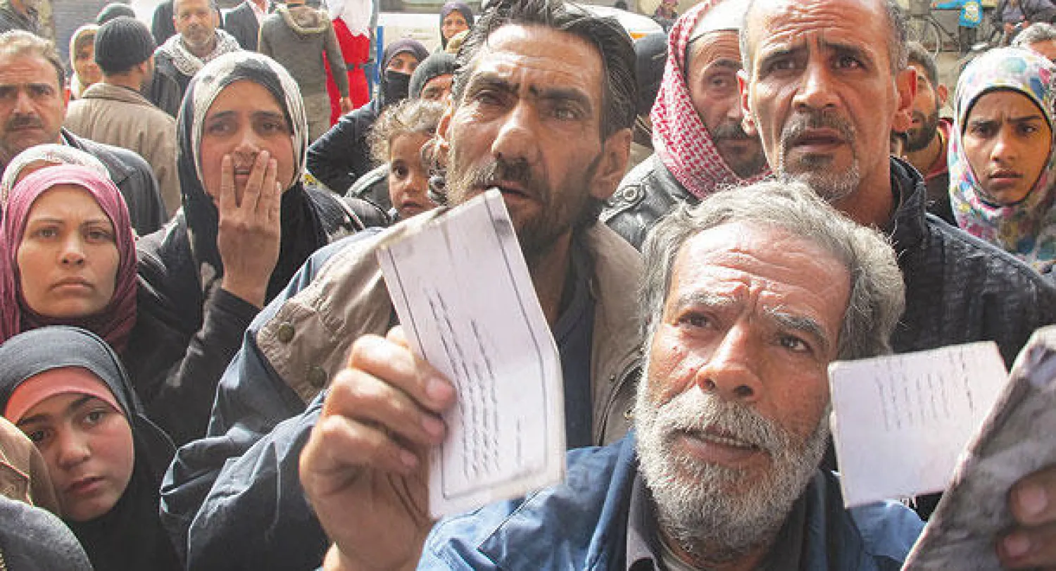 صورة وزعتها وكالة الغوث الفلسطينية أمس تظهر نازحين من مخيم اليرموك شمال دمشق الشهر الماضي (أ.ف.ب)