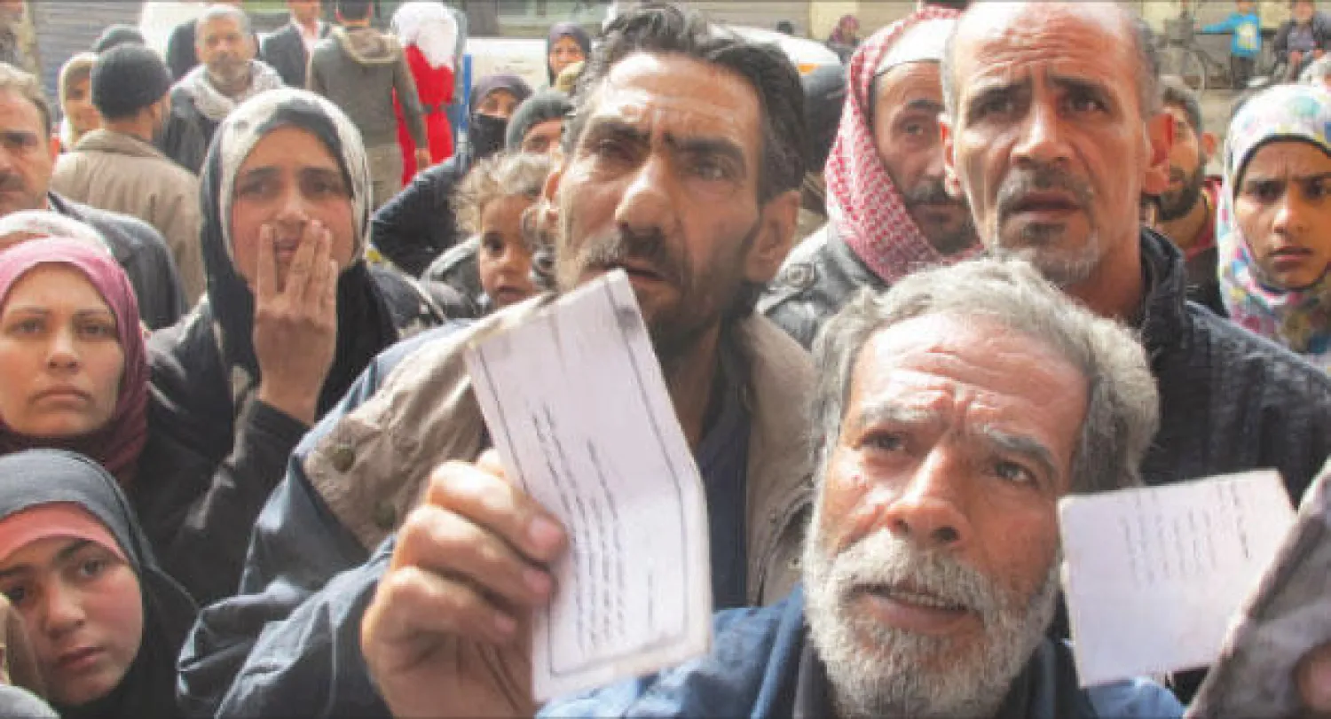 صورة وزعتها وكالة الغوث الفلسطينية أمس تظهر نازحين من مخيم اليرموك شمال دمشق الشهر الماضي (أ.ف.ب)