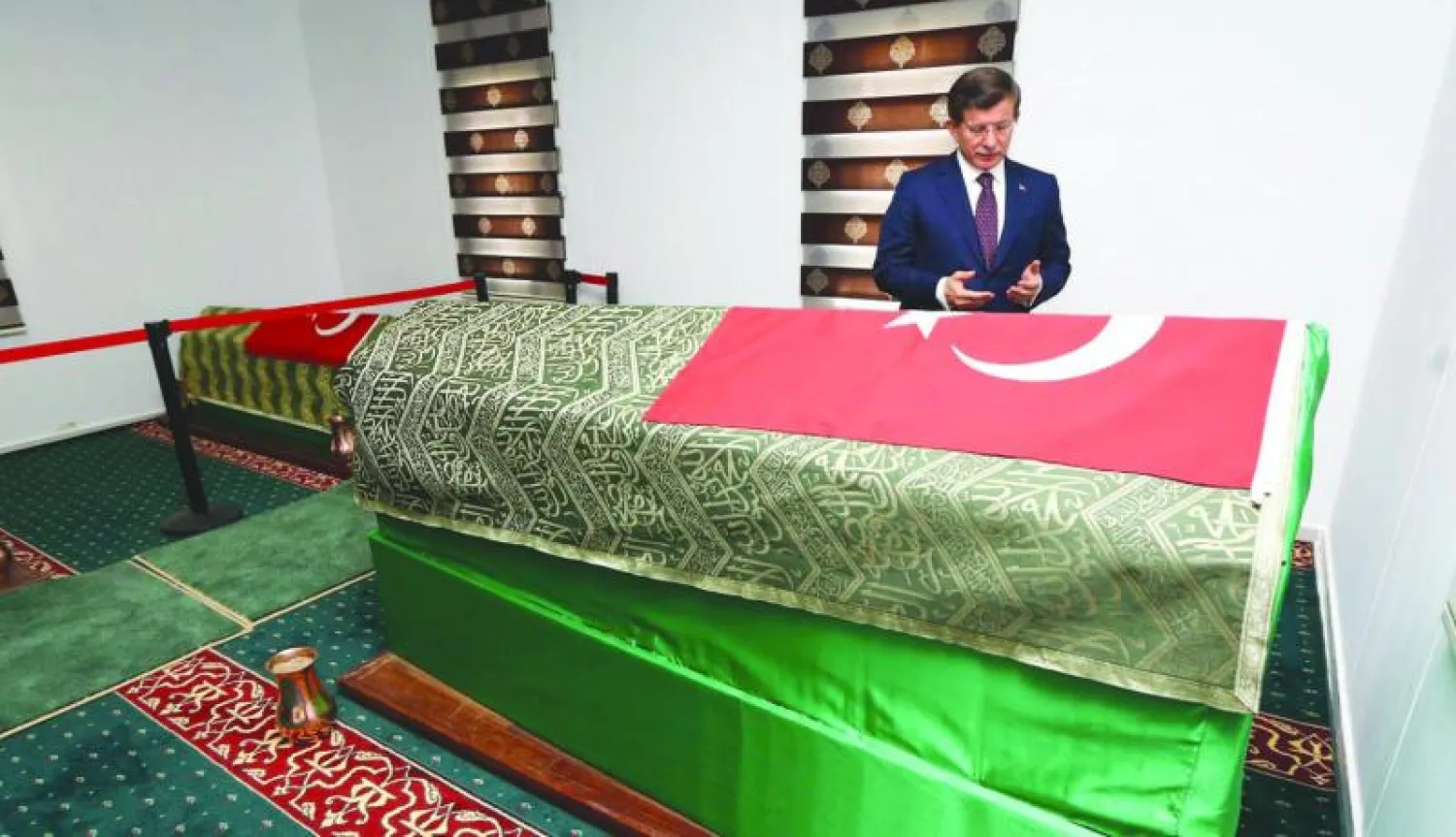 رئيس الوزراء التركي أحمد داود أوغلو يقرأ الفاتحة على روح سليمان شاه داخل الضريح الذي نقل الى قرية أشمة السورية (أ.ف.ب)