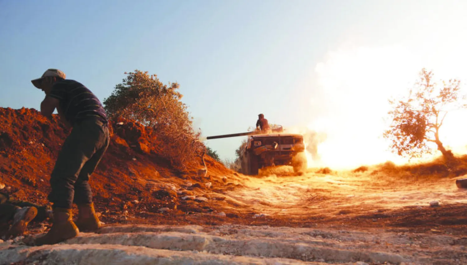 مقاتل من «لواء الفرقان» يسد أذنيه بعد إطلاق قذيفة على قوات الأسد في مواجهات للسيطرة على معسكر المسطومة أمس (رويترز)