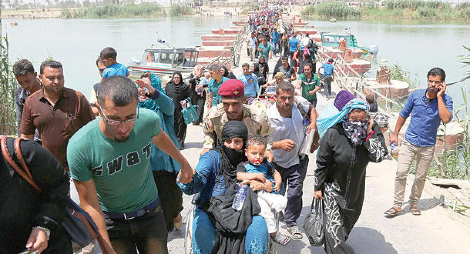 نازحون من الأنبار يعبرون جسر «بزيبز» بعد السماح لهم بالدخول إلى بغداد أمس (أ.ب)