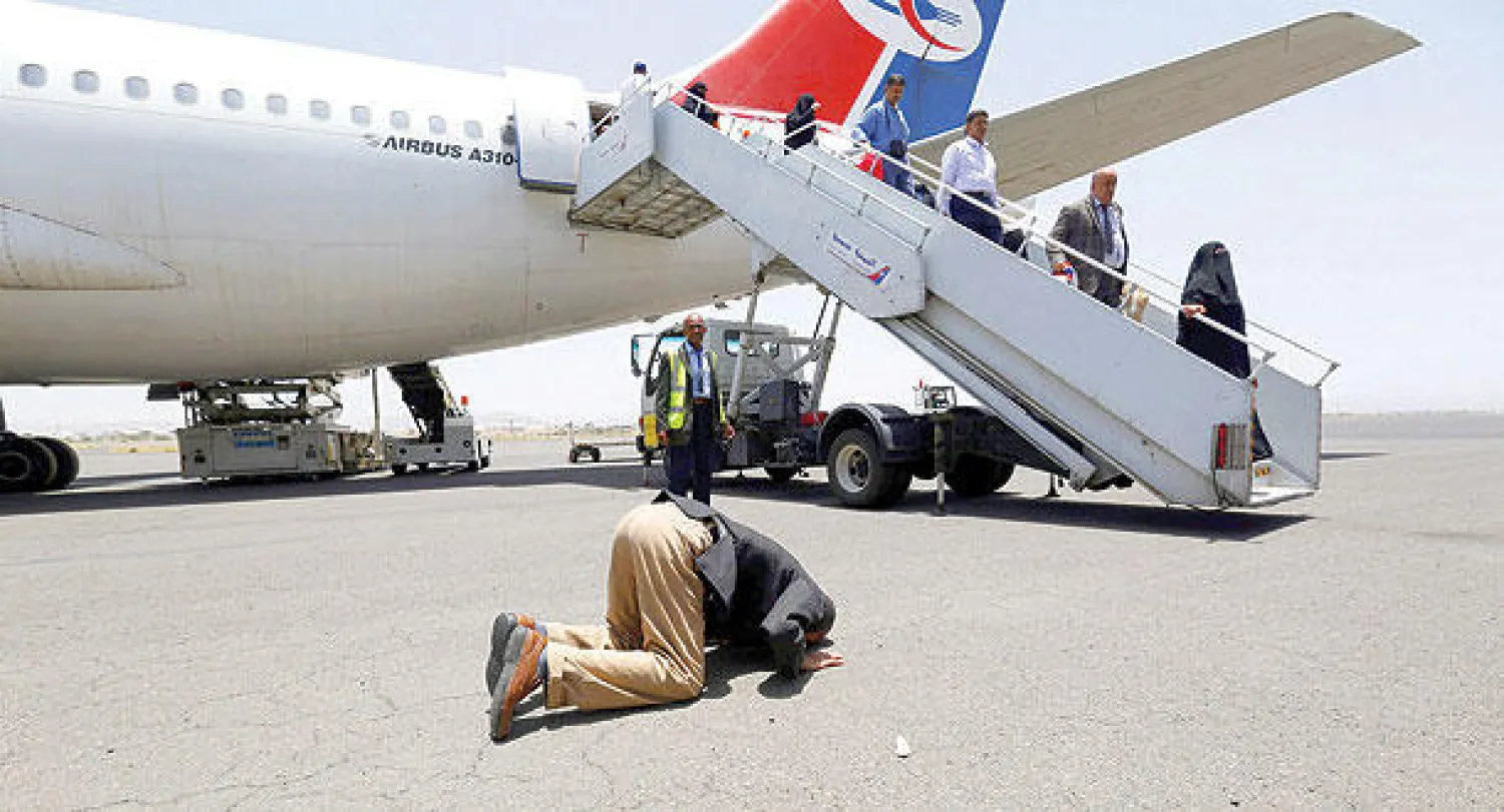 يمني يسجد شاكرا بعد وصوله مع مجموعة مكونة من 200 يمني كانوا عالقين في مصر إلى مطار صنعاء الدولي أمس (إ.ب.أ)