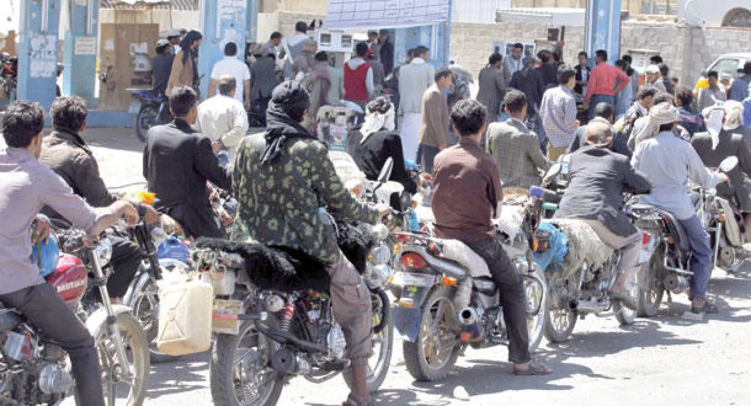 سائقو دراجات نارية يصطفون في انتظار دورهم للتزود بالوقود في صنعاء أمس (إ.ب.أ)