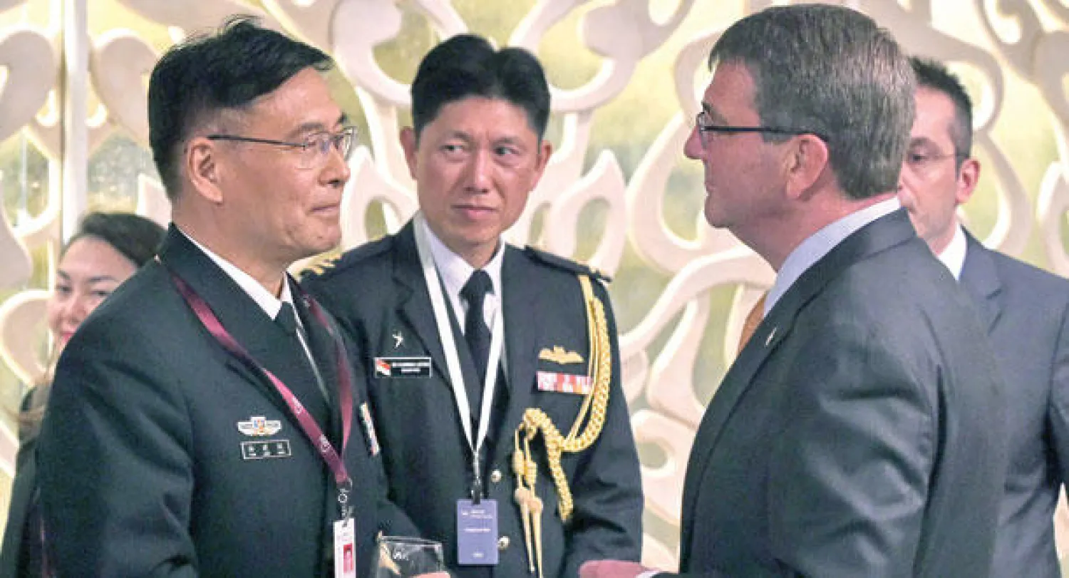 وزير الدفاع الأميركي آشتون كارتر (يمين) يتحدث إلى الكولونيل في الجيش الصيني جاو تشياوجو خلال مؤتمر «شانغري-لا» بسنغافورة أمس (أ.ف.ب)