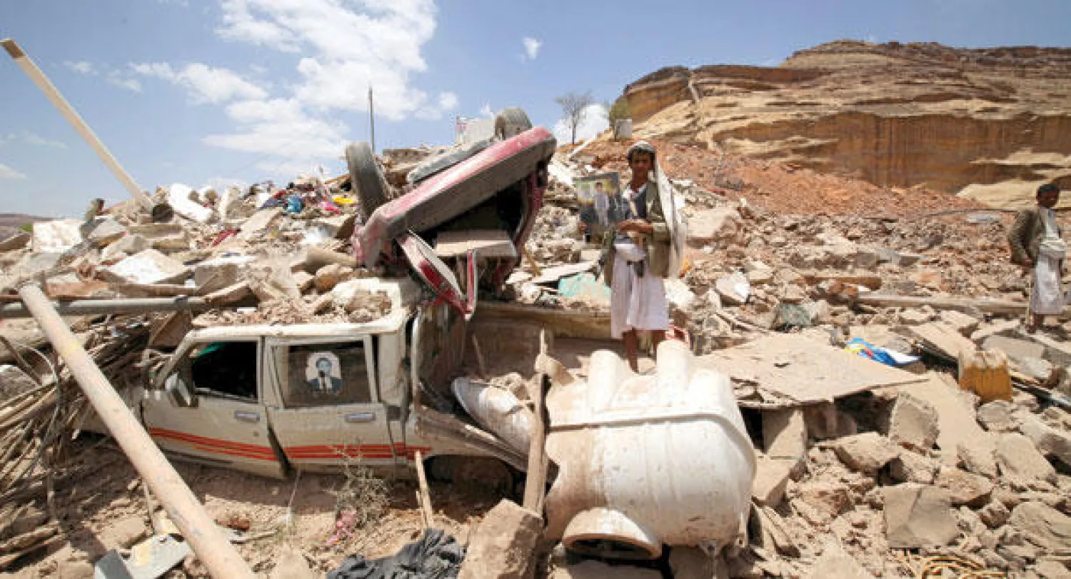 متشدد حوثي يقف وسط حطام منزل قيادي حوثي دمرته غارة جوية لقوات التحالف بالقرب من صنعاء أمس (رويترز)