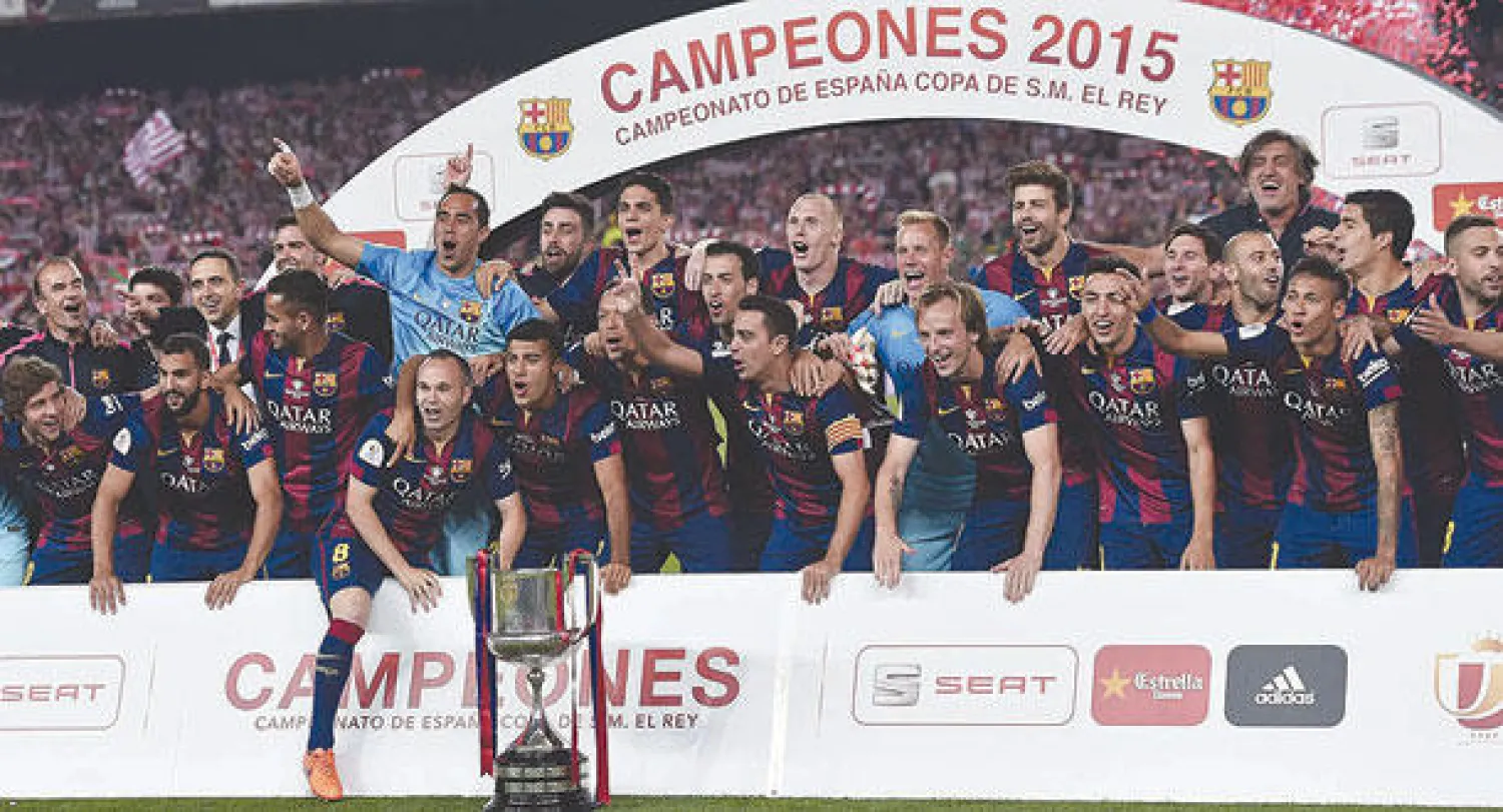 لاعبو برشلونة يحتفلون بالتتويج أبطالا لكأس إسبانيا بعد حصد الدوري (أ.ف.ب)