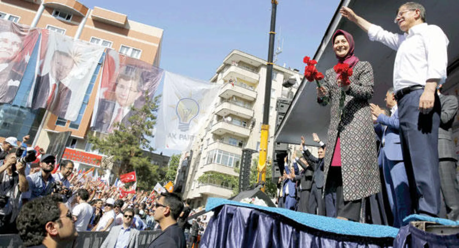 رئيس الوزراء التركي احمد داود اوغلو وزوجته يحييان مناصري حزبه {العدالة والتنمية} في مدينة كهرمان أمس اثناء حملة للانتخابات التي ستجرى في السابع من الشهر الحالي (رويترز)