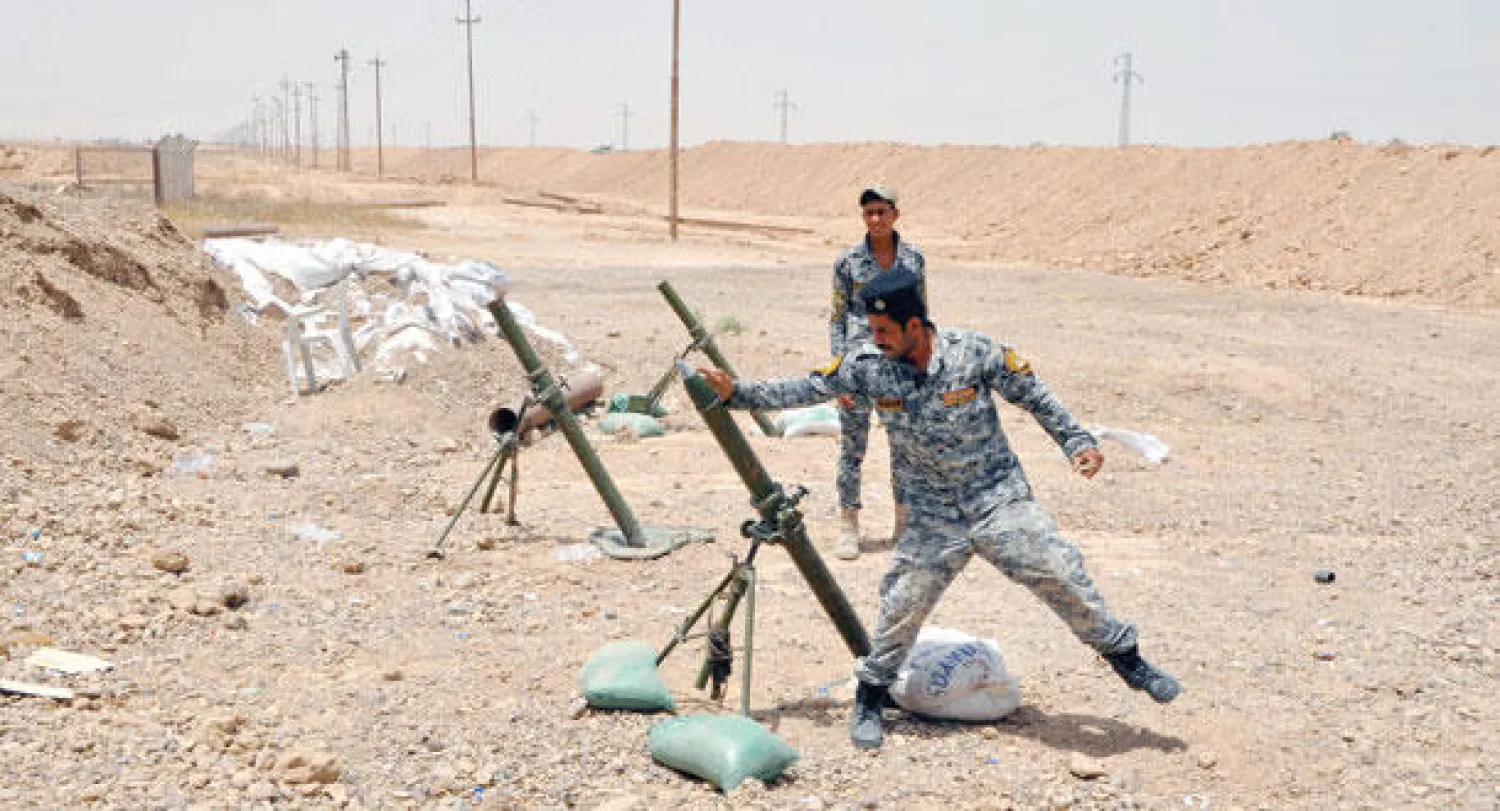 جندي عراقي يطلق قذيفة هاون على مواقع «داعش» غرب سامراء أول من أمس (إ.ب.أ)