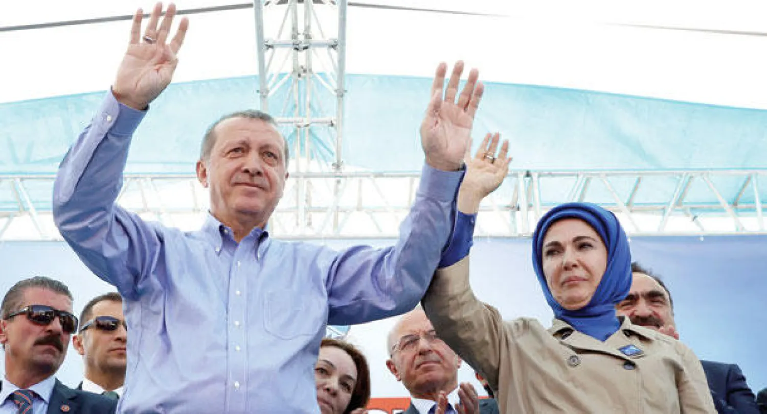 الرئيس التركي رجب طيب إردوغان مع زوجته يحييان الجماهير في أكاري أمس لدعم حزبه (العدالة والتنمية) في انتخابات اليوم (أ.ب)