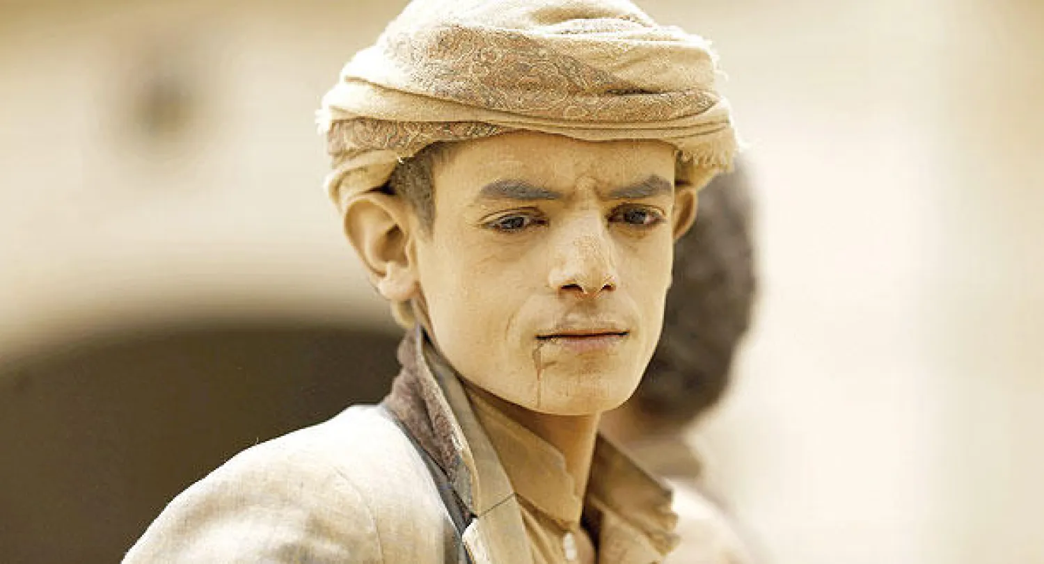 فتى مزارع غطى التراب وجهه لدى مغادرة عمله من إحدى المزارع قرب صنعاء أمس (رويترز)