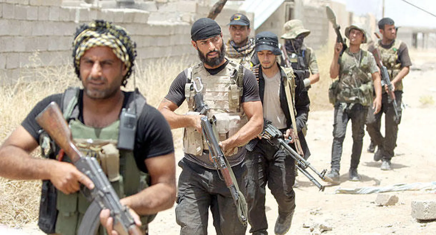 عناصر في ميليشيات الحشد الشعبي ينتشرون في بيجي إلى الشمال من تكريت أمس (أ.ف.ب)