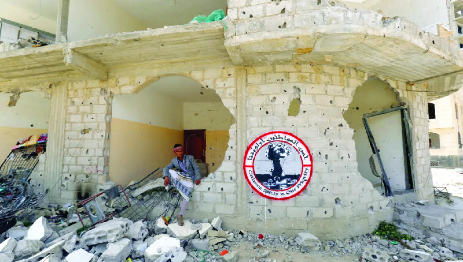 نازح يمني يجلس على أنقاض مبنى دمرته غارة جوية في صنعاء متخذة مأوى مؤقتًا بعد تفاقم الأوضاع  المعيشية في اليمن (إ.ب.أ)