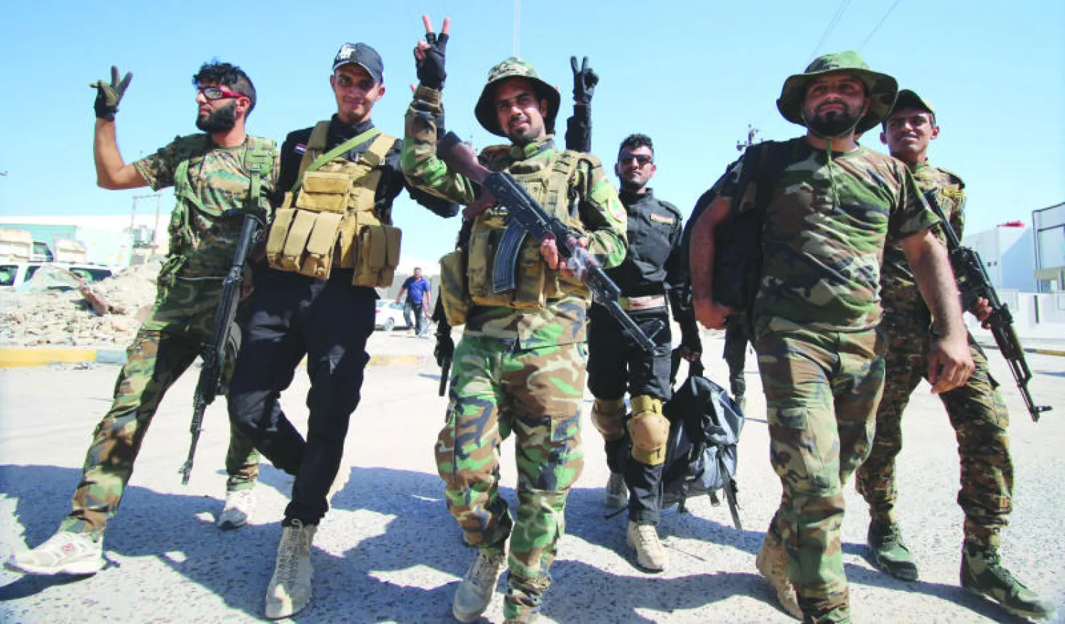 عناصر في «عصائب أهل الحق» المنضوية ضمن ميليشيات «الحشد الشعبي» لدى وصولهم إلى البصرة أمس عائدين من جبهات القتال مع «داعش» (أ.ف.ب)