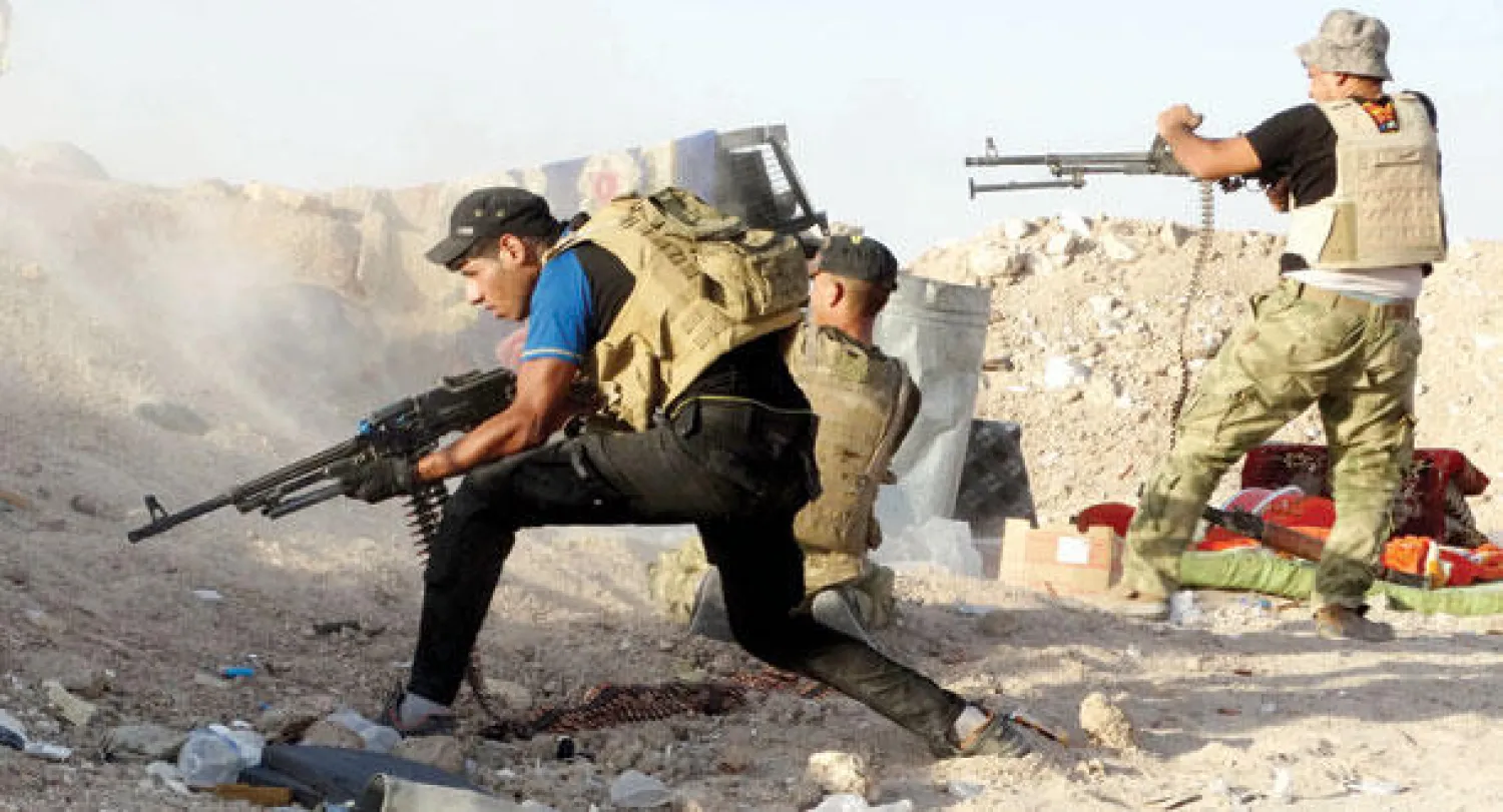 مقاتلون من القوات العراقية المشتركة يفتحون النار ضد «داعش» في بلدة حصيبة شرق الرمادي أول من أمس (أ.ب)