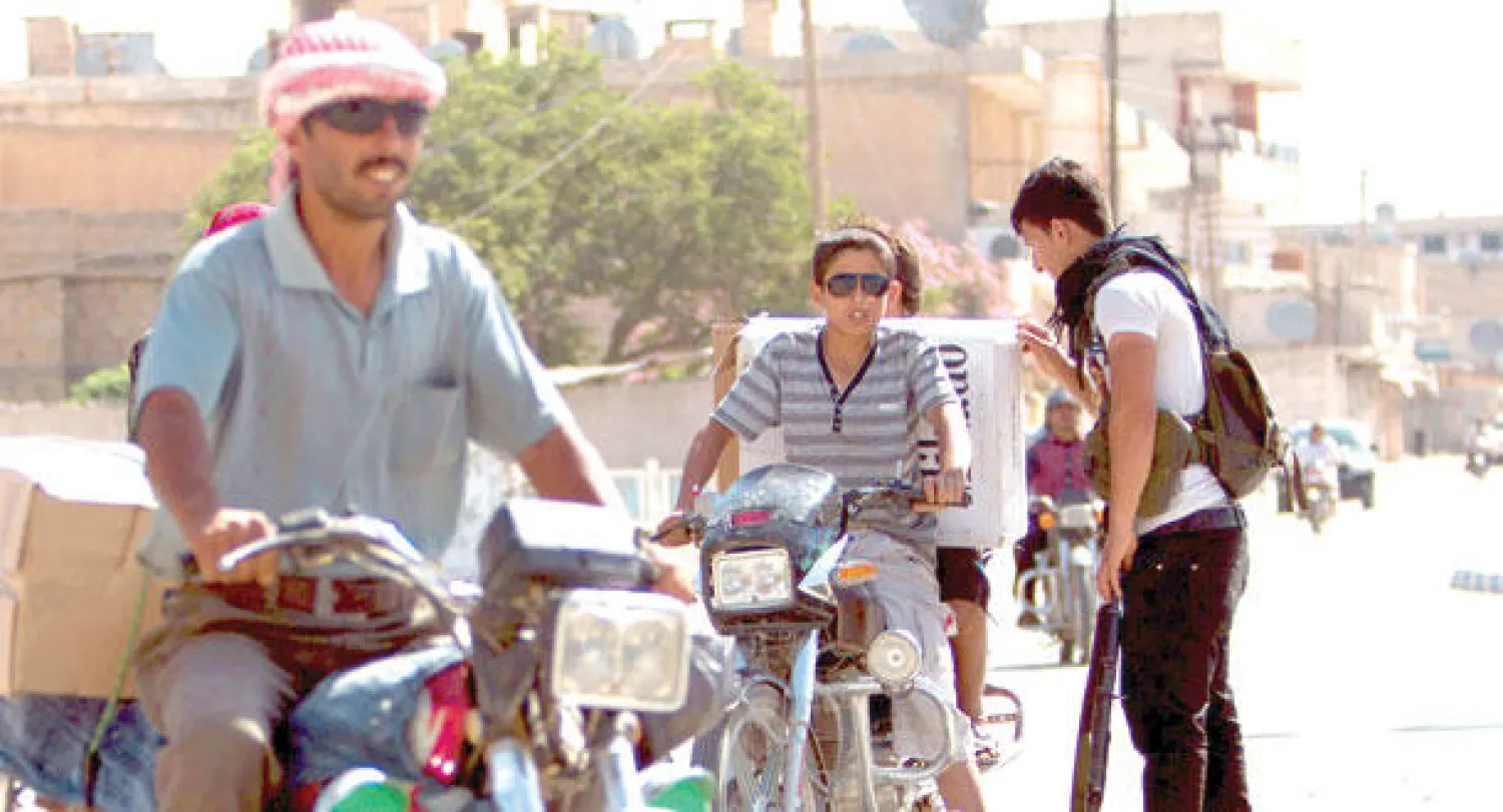 مقاتل كردي في نقطة تفتيش بمدينة تل أبيض على الحدود التركية أمس (رويترز)