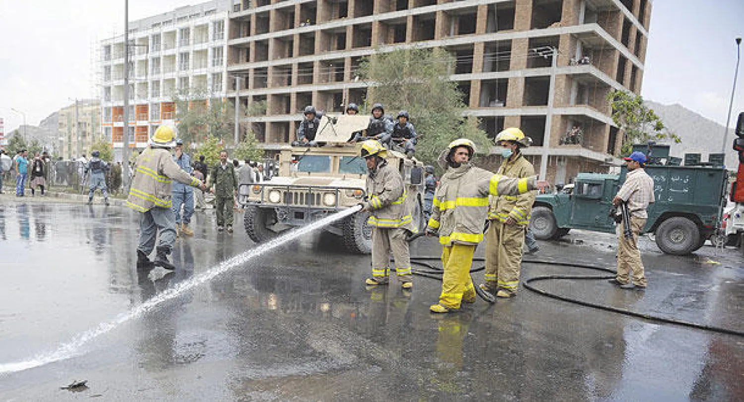 إزالة آثار التفجير الانتحاري من أمام مقر البرلمان الأفغاني الذي أدى إلى مقتل 7 مسلحين من طالبان وإصابة العشرات غرب العاصمة كابل أمس (إ.ب.أ)