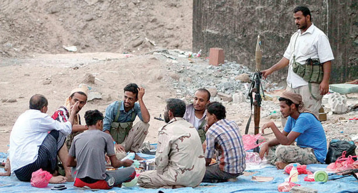 عناصر من المقاومة الشعبية الموالية للرئيس هادي يتناولون إفطارا رمضانيا جماعيا أول من أمس في عدن (أ.ف.ب)