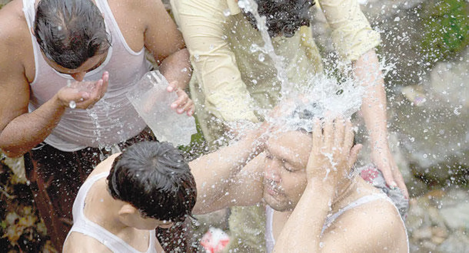 باكستانيون يتبردون من خط مياه مكسور في إسلام آباد خلال شهر رمضان أمس (أ.ب)