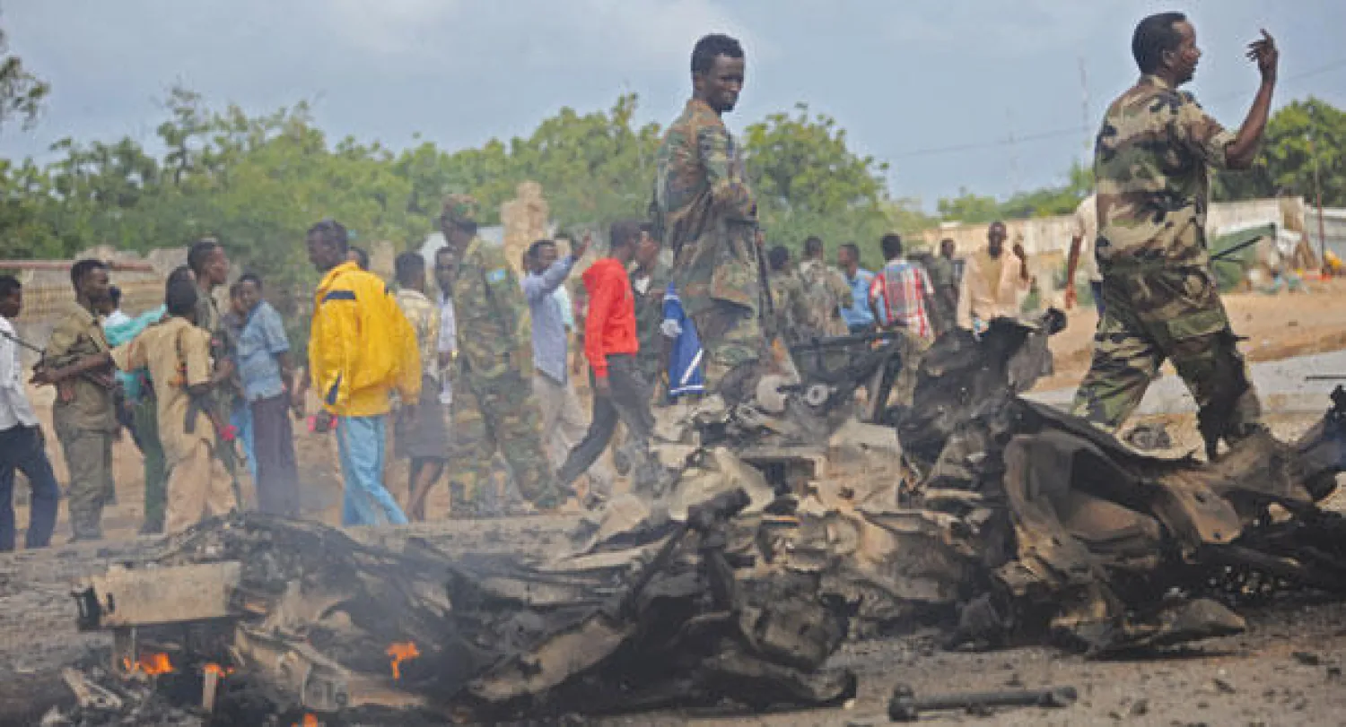 جنود صوماليون وجمهور من المواطنين في منطقة الحادث أمس (أ.ف.ب)