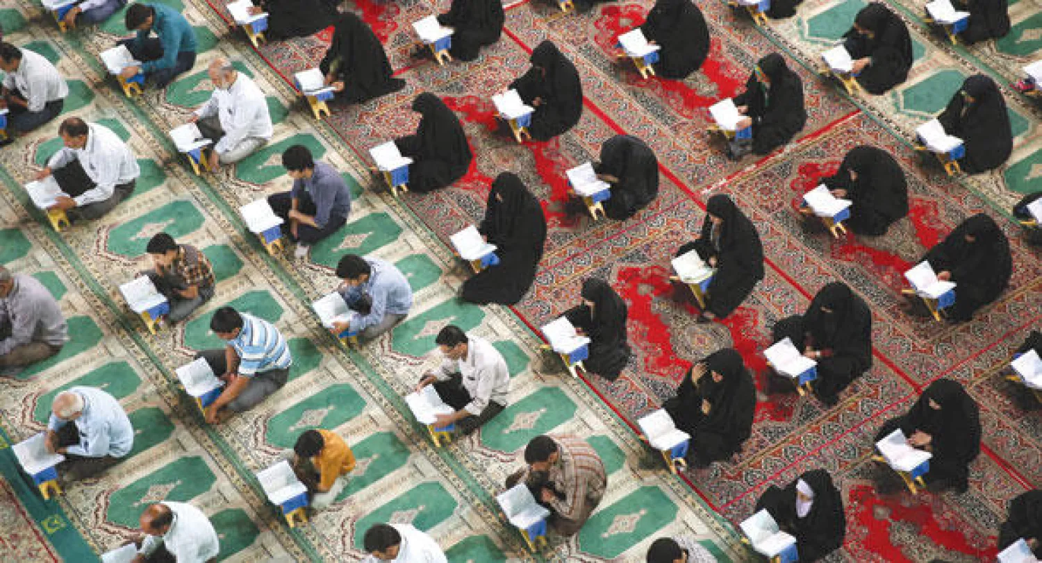 إيرانيون وإيرانيات يتلون القرآن الكريم في مسجد محمد بن هلال بن علي بمدينة آران (140 ميلاً جنوب طهران) وذلك بمناسبة شهر رمضان المبارك (أ.ف.ب)