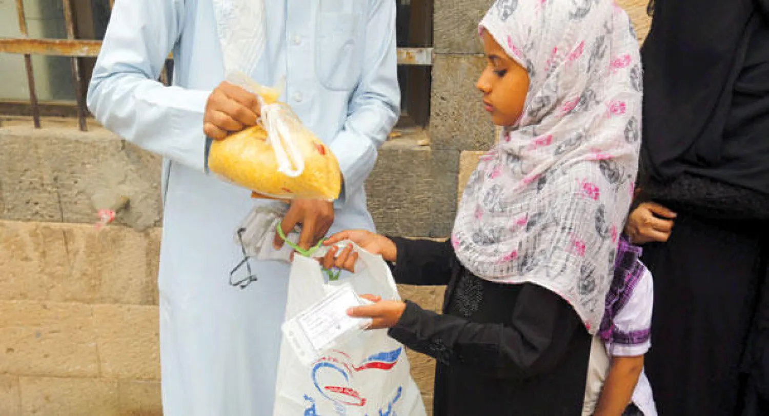 طفلة يمنية أثناء تسلم مواد غذائية من مركز إغاثة في صنعاء أمس (إ.ب.أ)