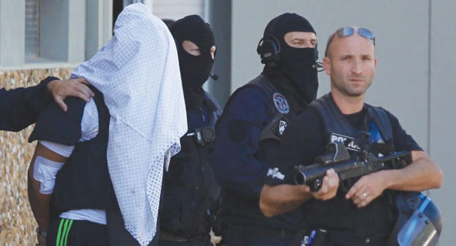 ياسين صالحي المشتبه به في تفجيرات ليون خلال اقتياده إلى مقر التحقيقات في سانت بارييه أمس (رويترز)