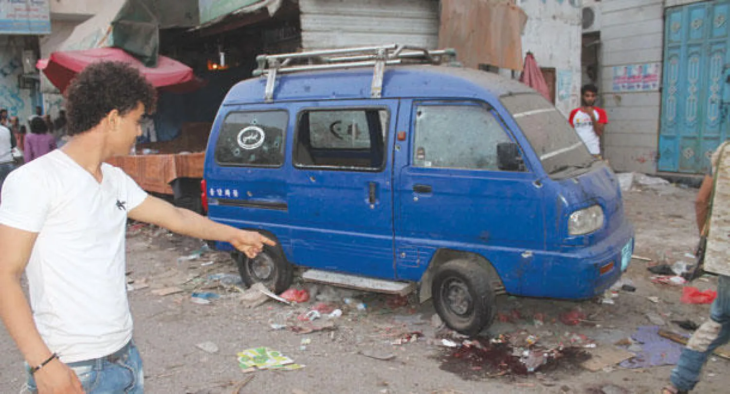 يمني يؤشر إلى المكان الذي سقط فيه أحد ضحايا المجزرة التي ارتكبتها الميليشيات الحوثية في عدن أمس (أ.ف.ب)