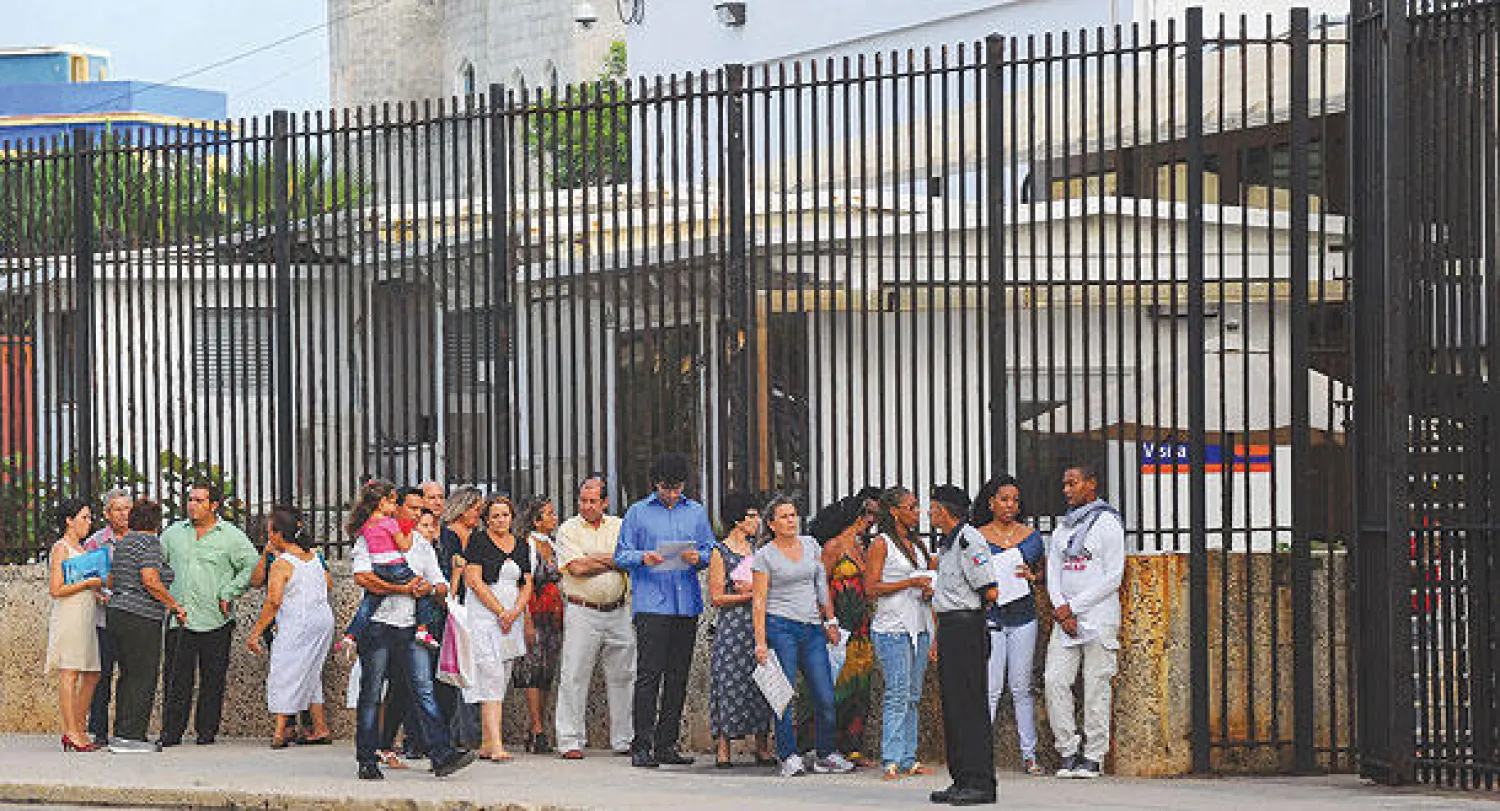 كوبيون ينتظرون خارج قسم المصالح الأميركية في هافانا للتقدم بطلبات الحصول على التأشيرة أمس (أ.ف.ب)