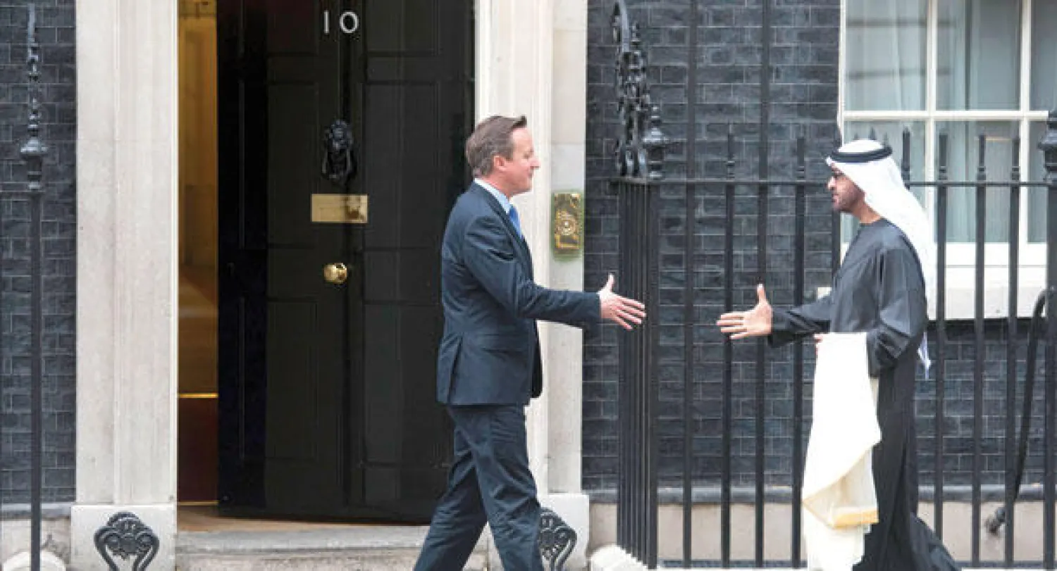 رئيس الوزراء البريطاني ديفيد كاميرون يستقبل ولي عهد أبوظبي محمد بن زايد أمام مقر الحكومة البريطانية في لندن أمس (إ.ب.أ)