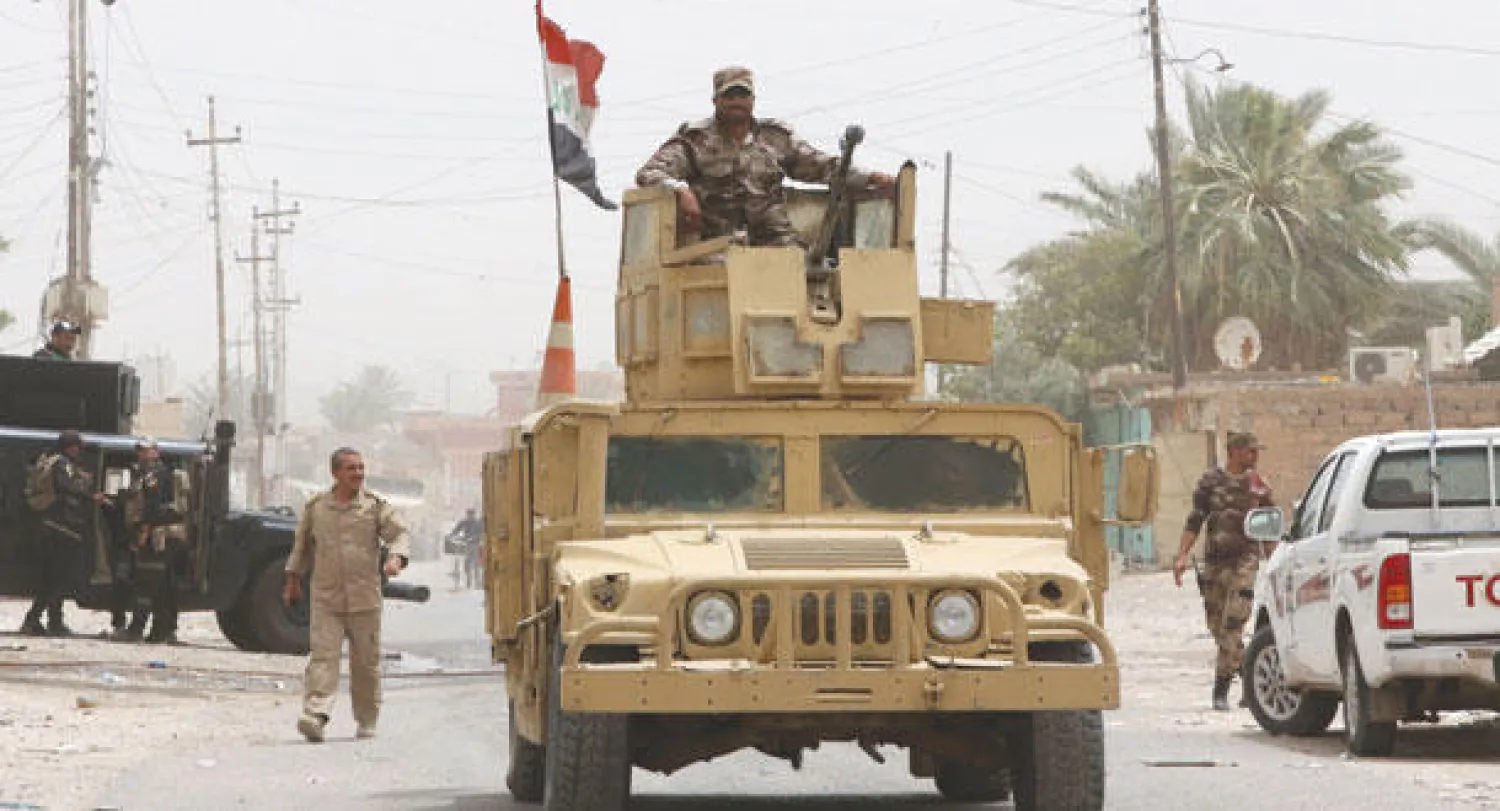 جندي عراقي من القوات الخاصة يقف فوق عربة همر المدرعة وسط مدينة بيجي أمس(أ.ف.ب)