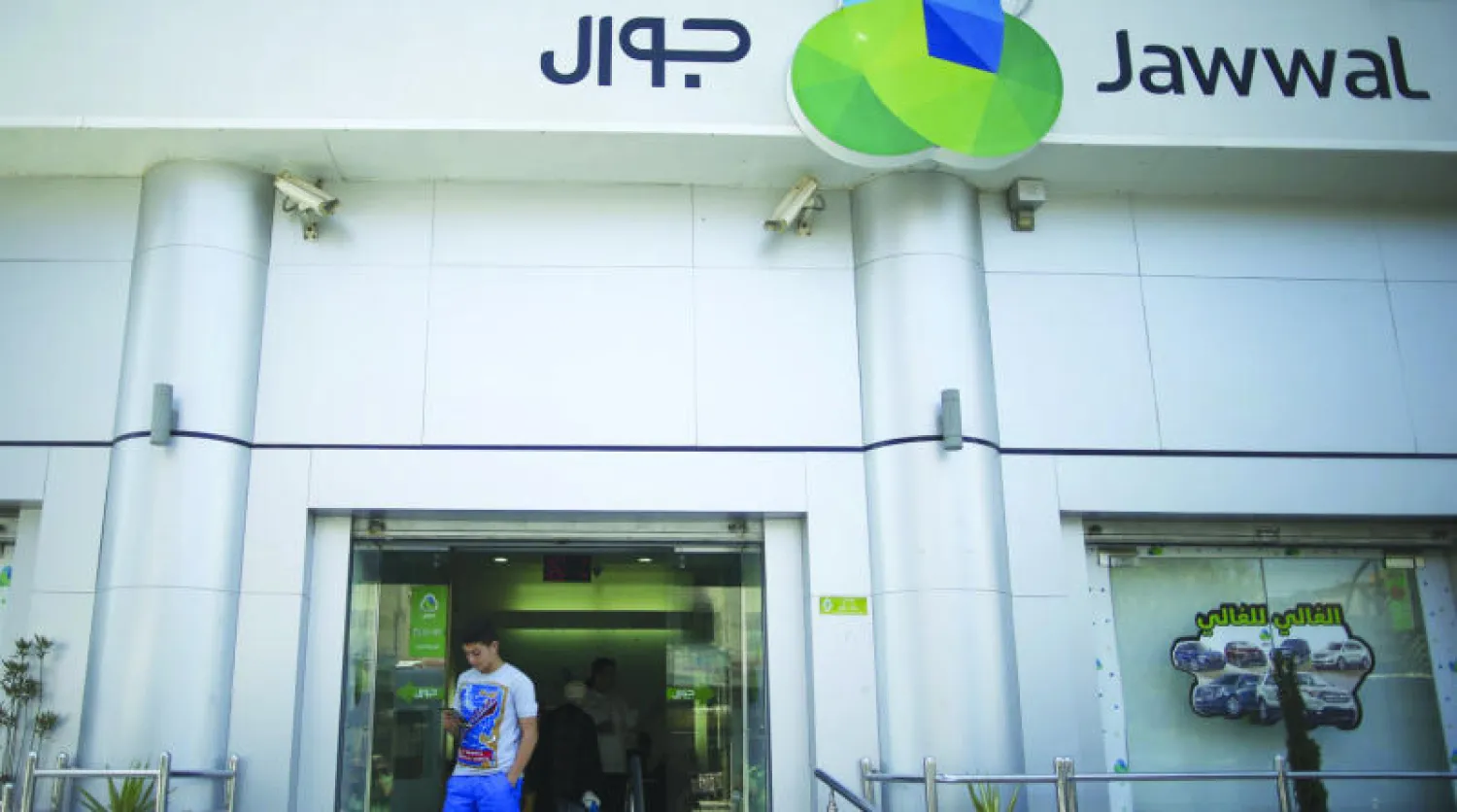 فلسطيني شاب يغادر المبنى الرئيسي لشركة {جوال} للاتصالات في غزة بعد إعادة فتحه اليوم (رويترز)