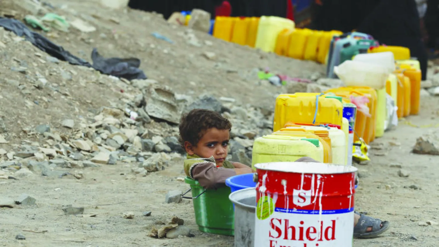 طفلة يمنية تجلس على «جركن» فارغ انتظارا لملئه بالماء وسط تعطل إمدادات المياه بالعاصمة اليمنية صنعاء (أ.ب)