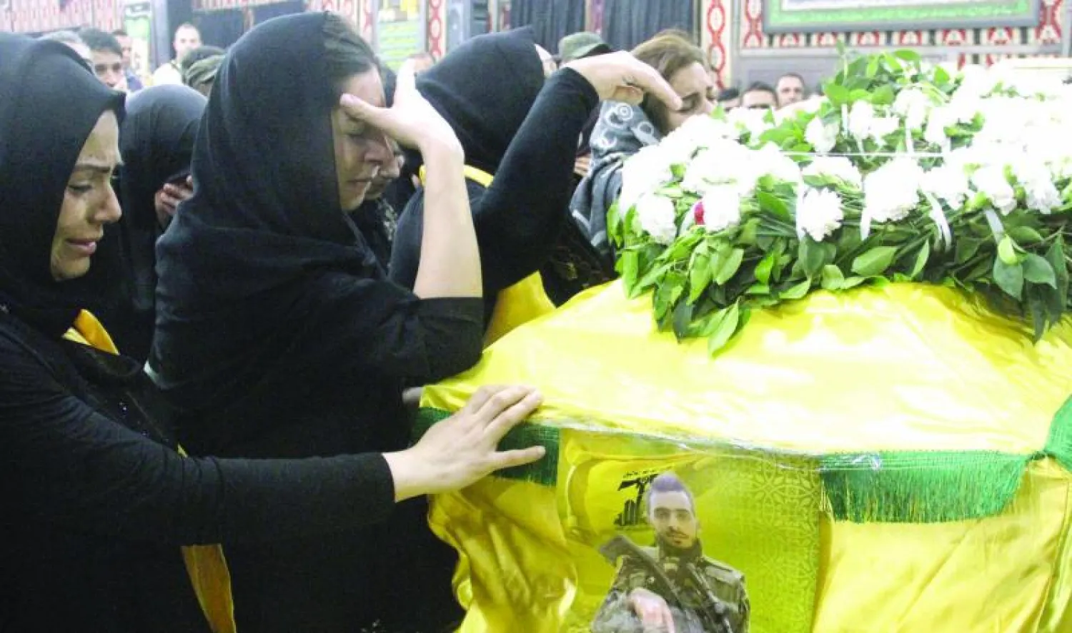 لبنانيات من عائلة مقاتل تابع لحزب الله سقط في معارك القلمون يبكين فوق جثمانه الذي شيع أمس في الضاحية الجنوبية ببيروت (أ.ف.ب)