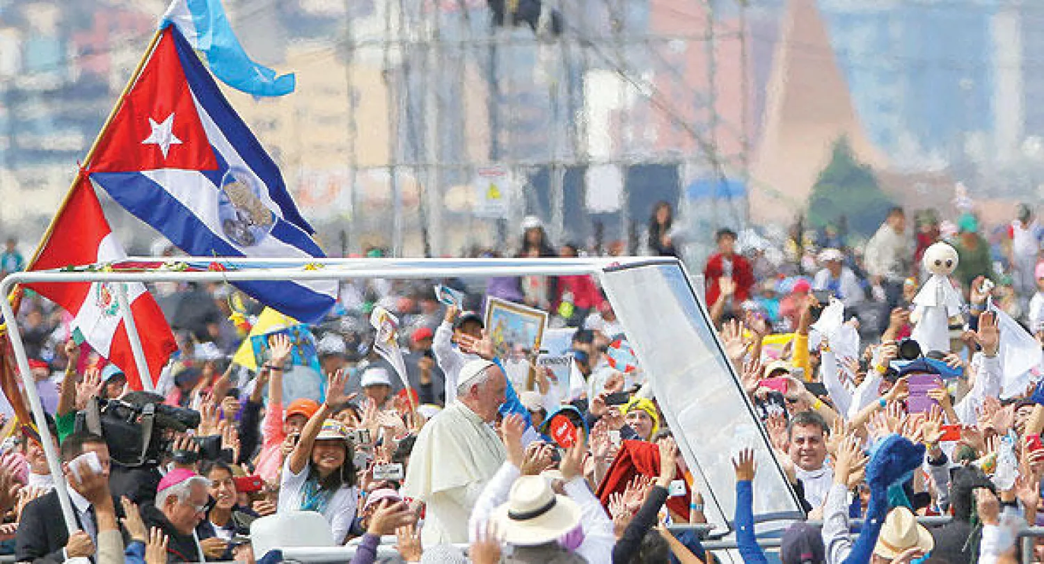 البابا فرنسيس يحيي محبيه داخل عربته في عاصمة الإكوادور كيتو أمس (أ.ب)