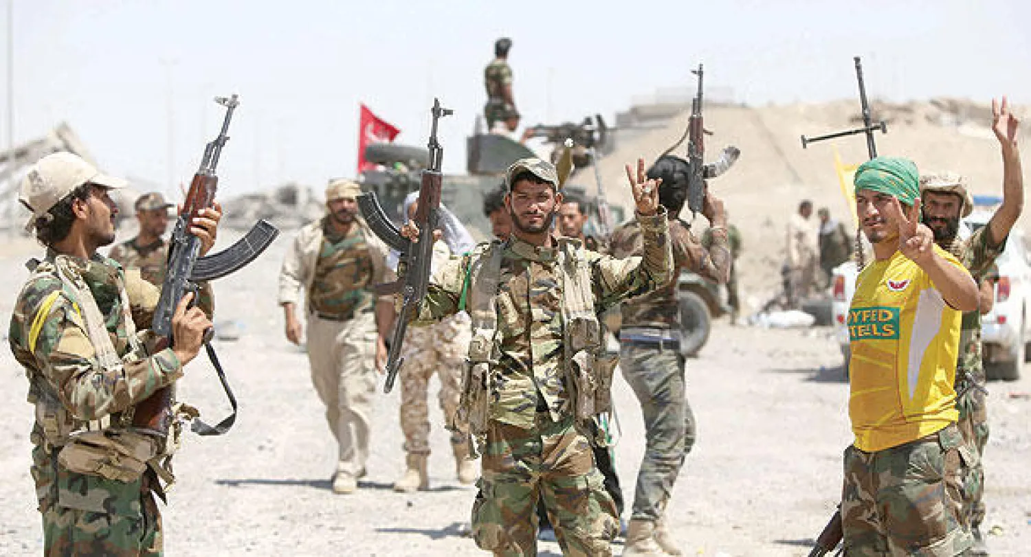 مقاتلون من متطوعي الحشد الشعبي يحتفلون بتحقيق انتصار في معركة شمال الفلوجة أمس (أ.ف.ب)